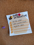 Bee Productive note pinned up on a cork board. The note has three tasks written on it, one of which is checked off.